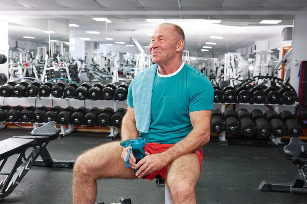 a man sitting on a bench in a gym