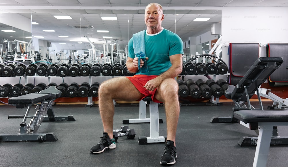 a man sitting on a bench in a gym