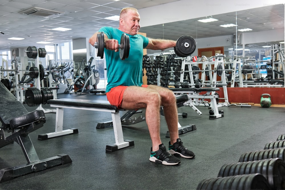 a man is sitting on a bench in a gym