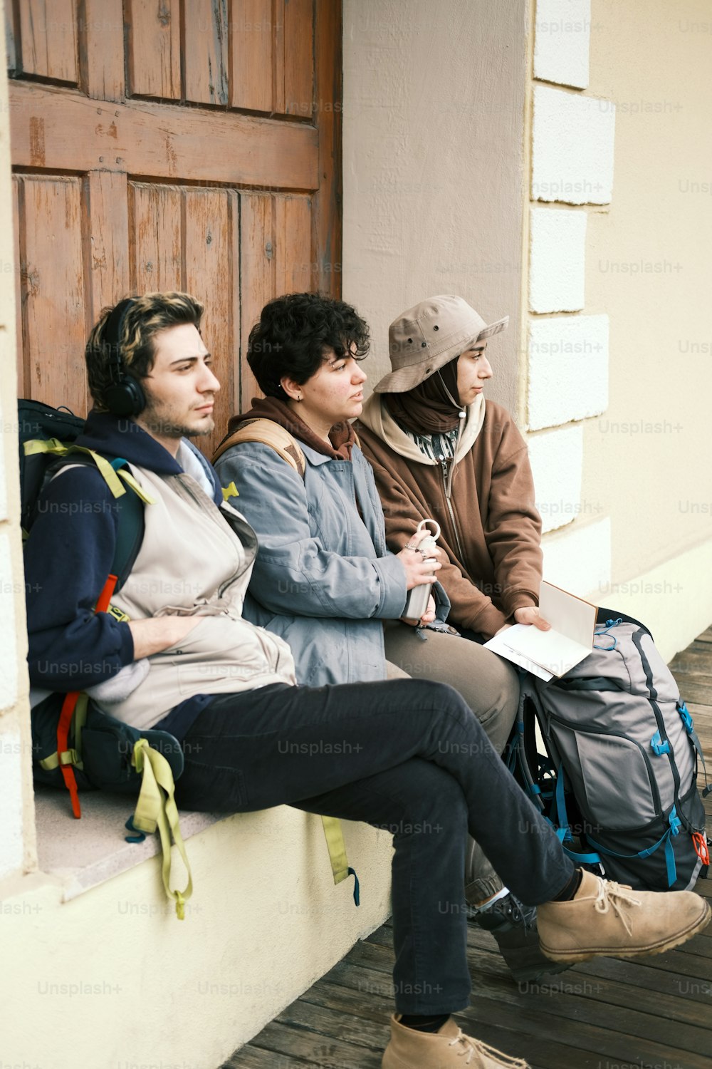 a group of people sitting on a porch next to each other