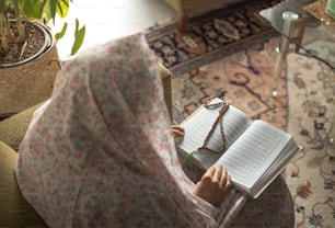 a woman sitting on a couch reading a book