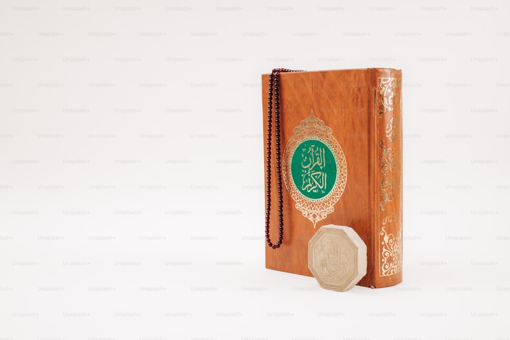 Un livre en bois avec une couverture verte et or