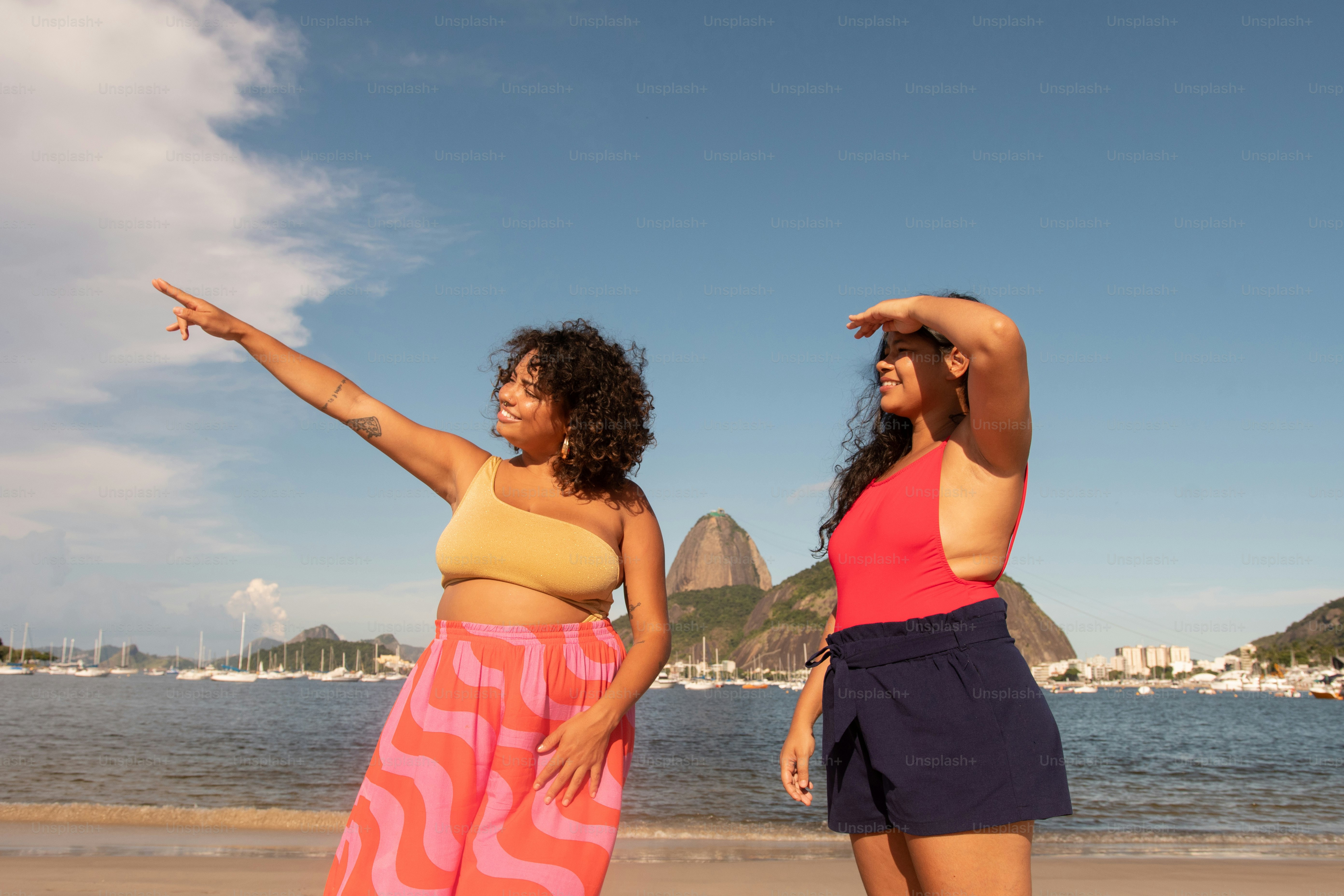 a couple of women standing next to each other on a beach
