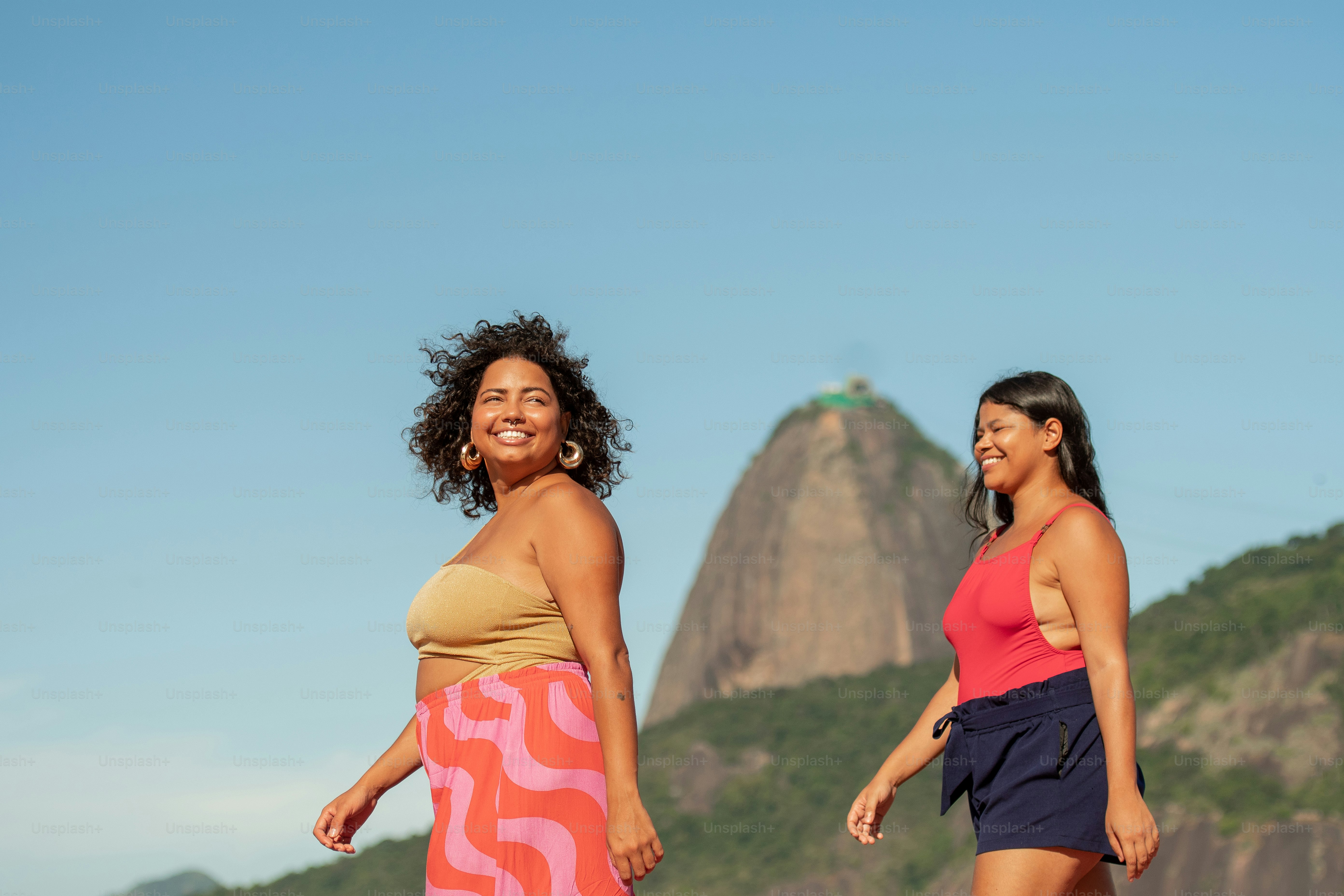 a couple of women standing next to each other on a beach