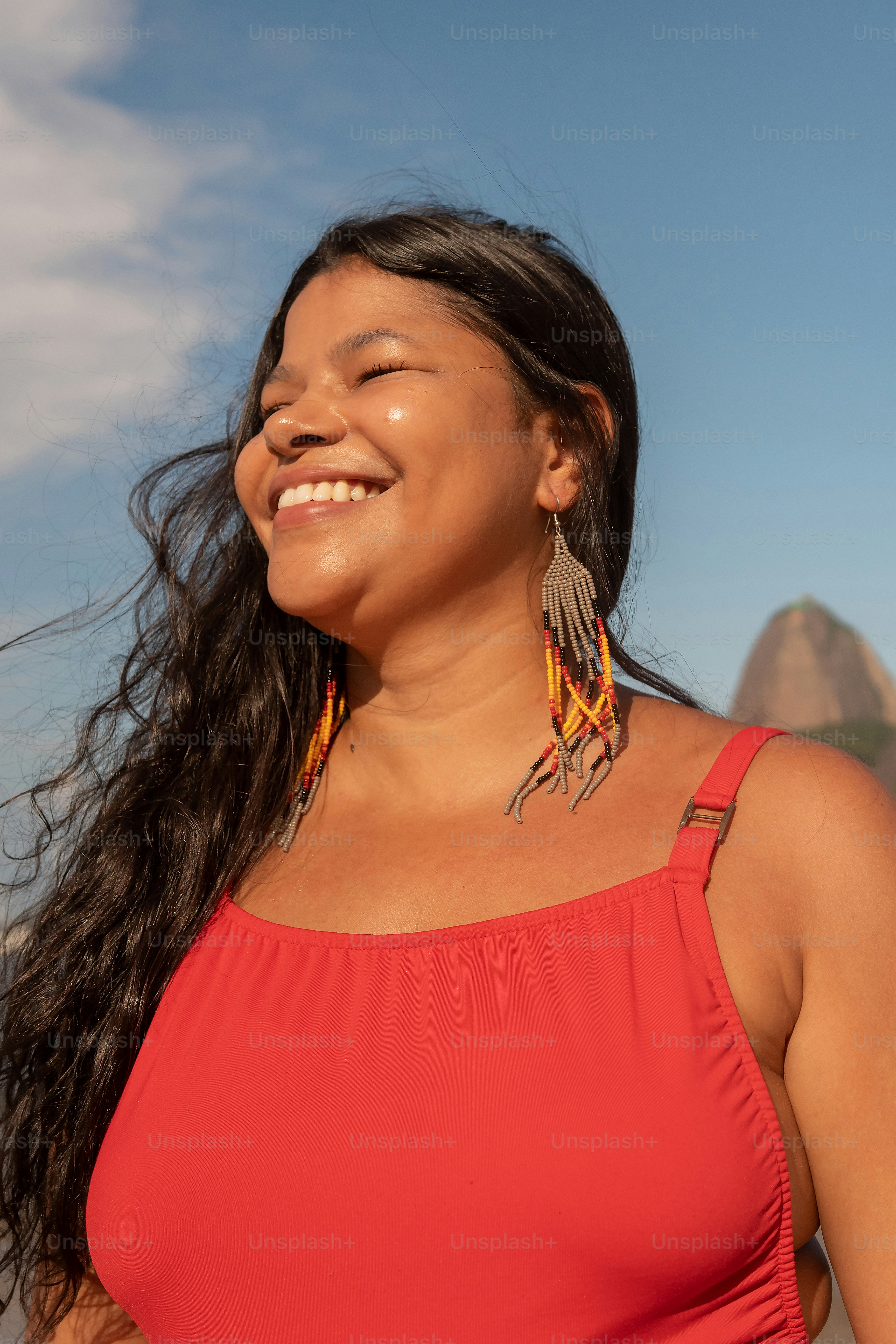 a woman in a red top smiles at the camera