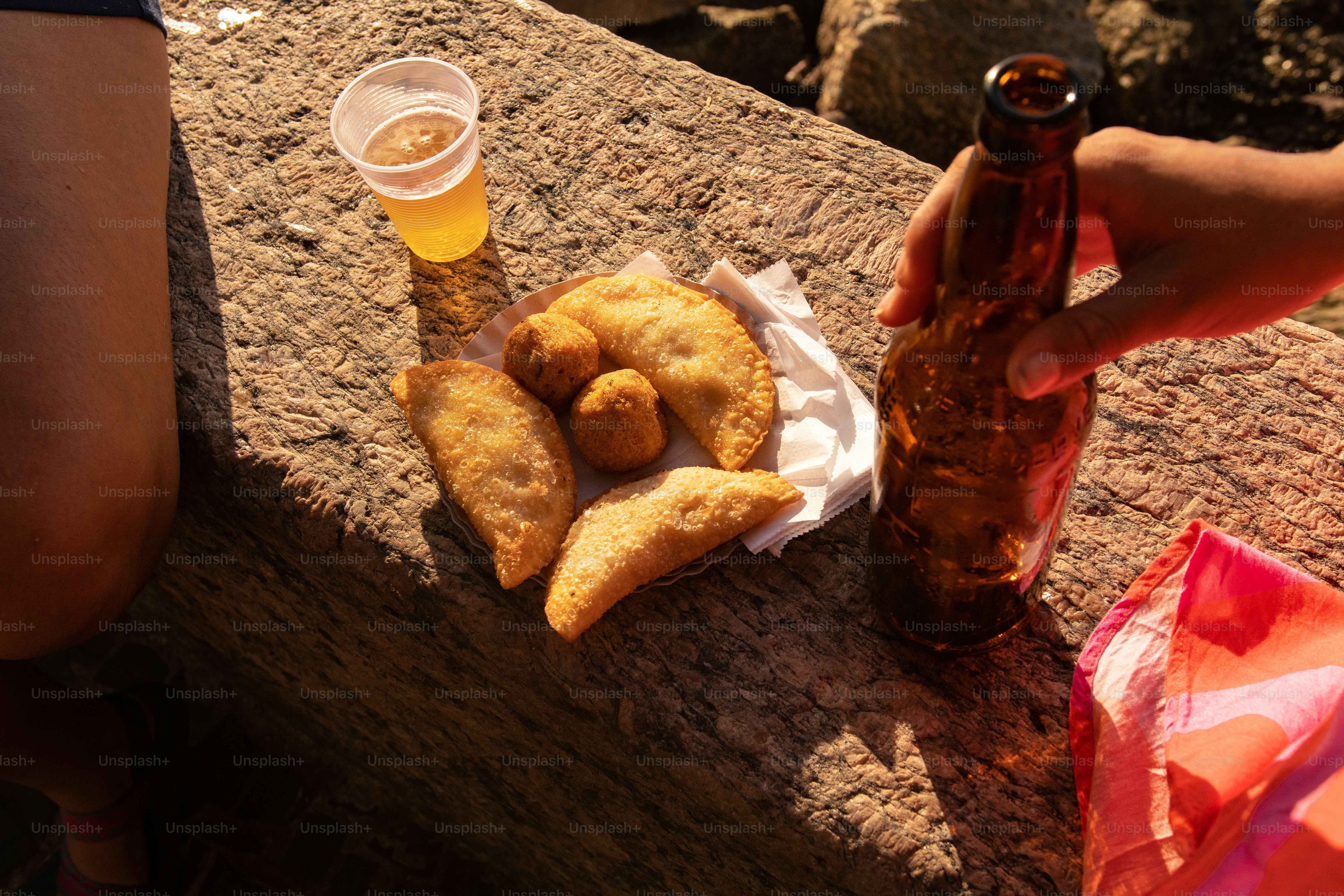a person holding a beer and some food