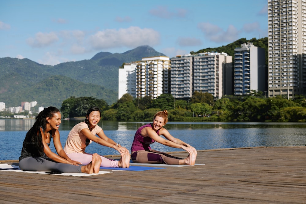 Un grupo de mujeres sentadas encima de colchonetas de yoga