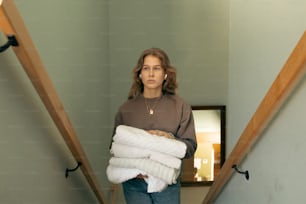 Una mujer sosteniendo una pila de toallas dobladas