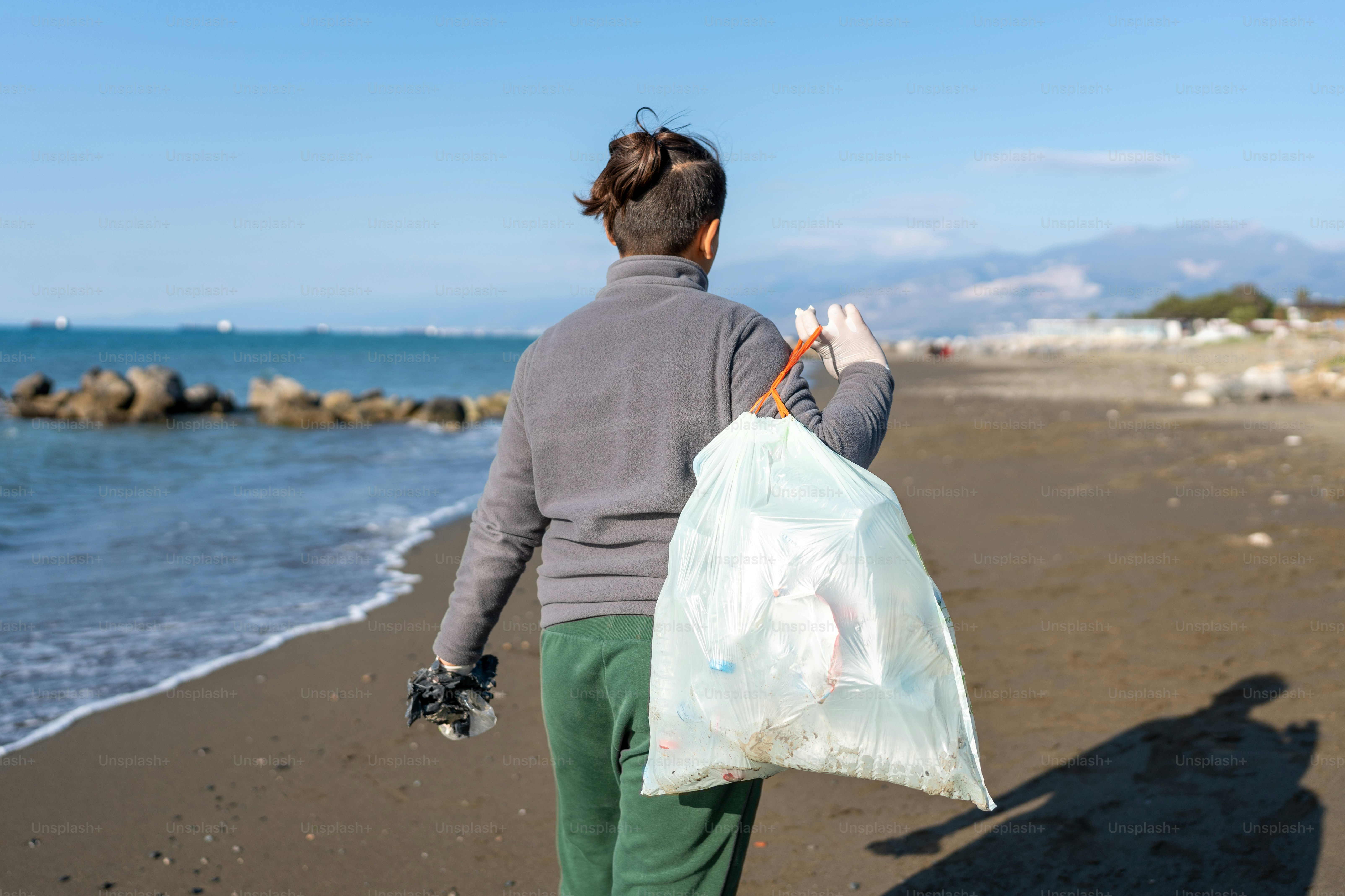 a person walking on a beach with a bag