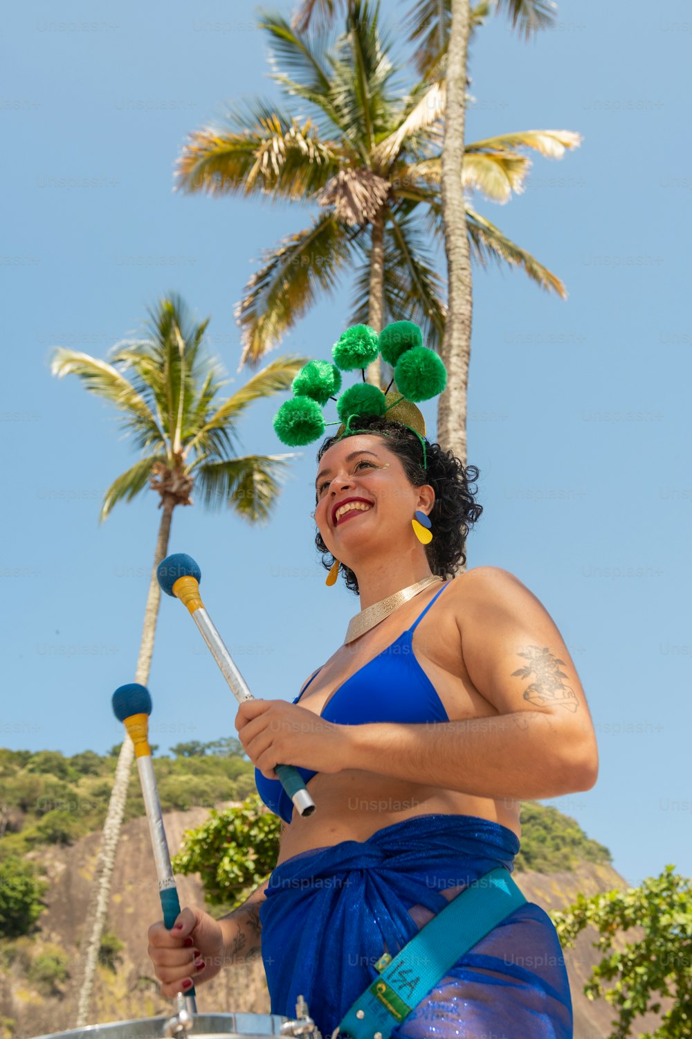 Una mujer en bikini azul sosteniendo un poste