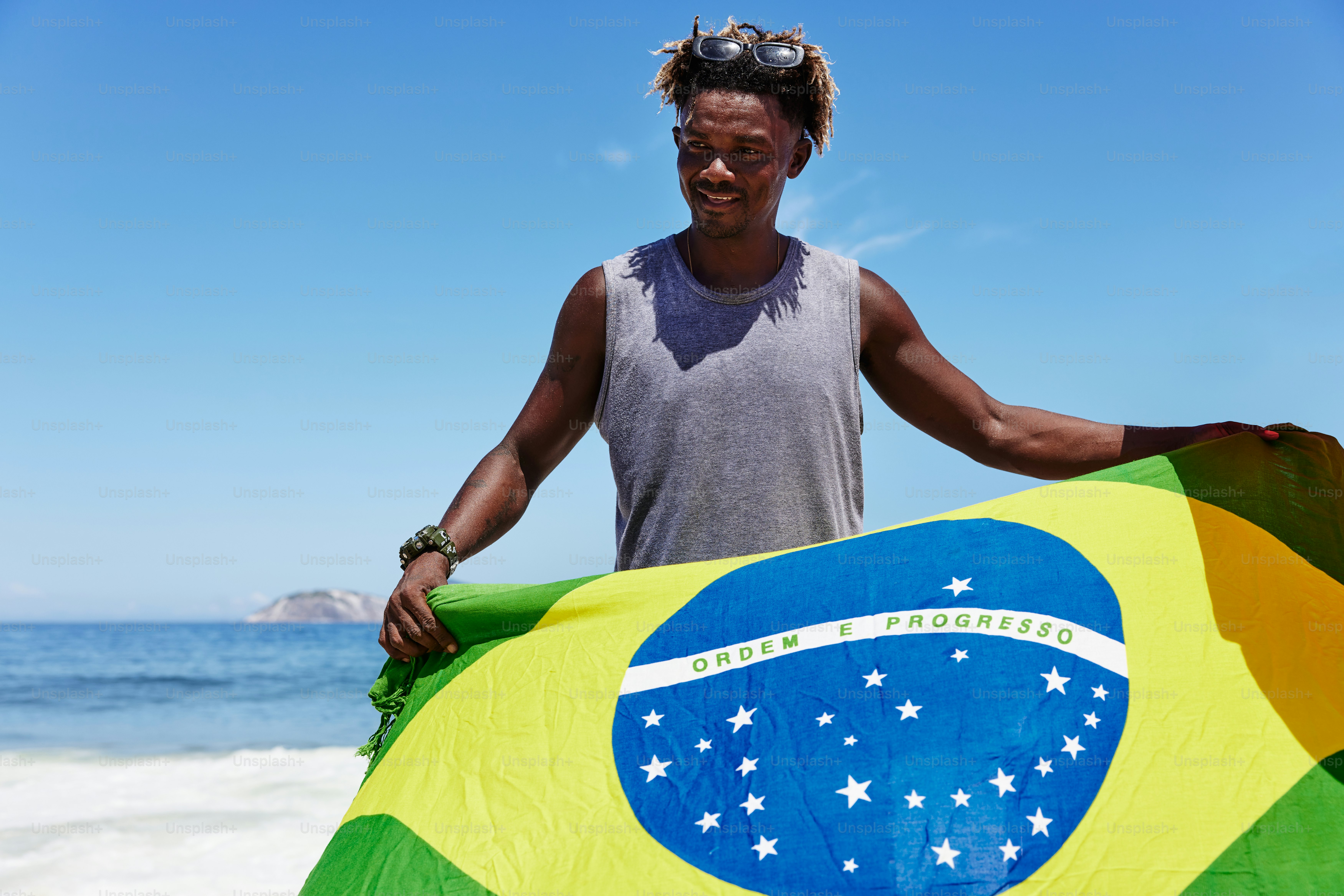 a man holding a large flag on the beach