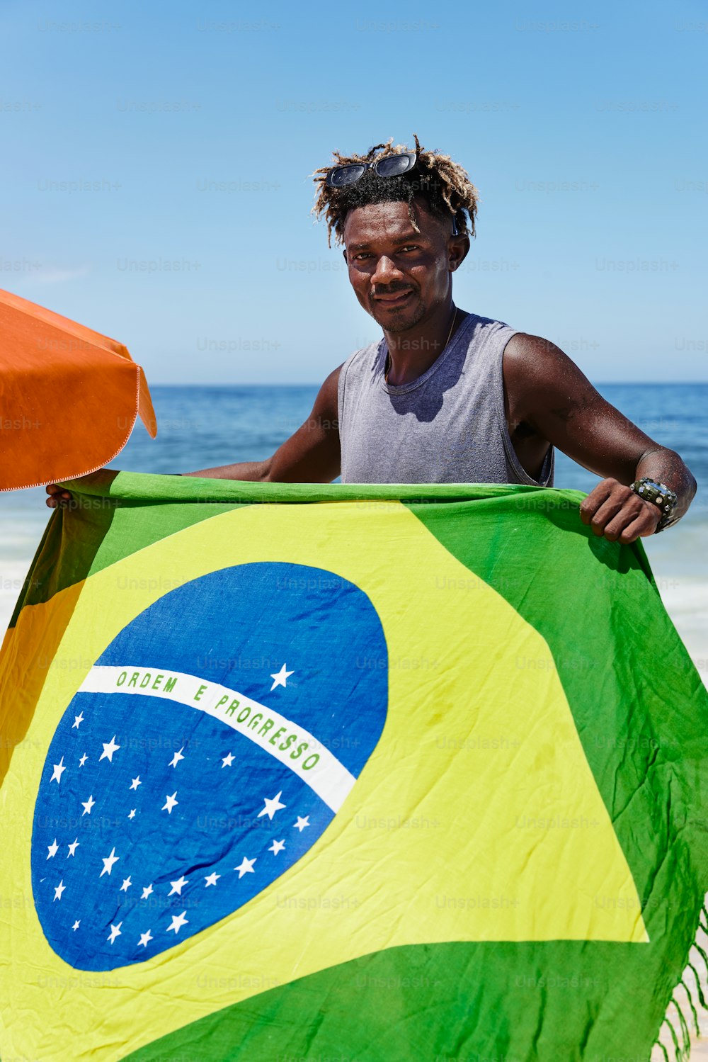 Un hombre sosteniendo una bandera en la playa