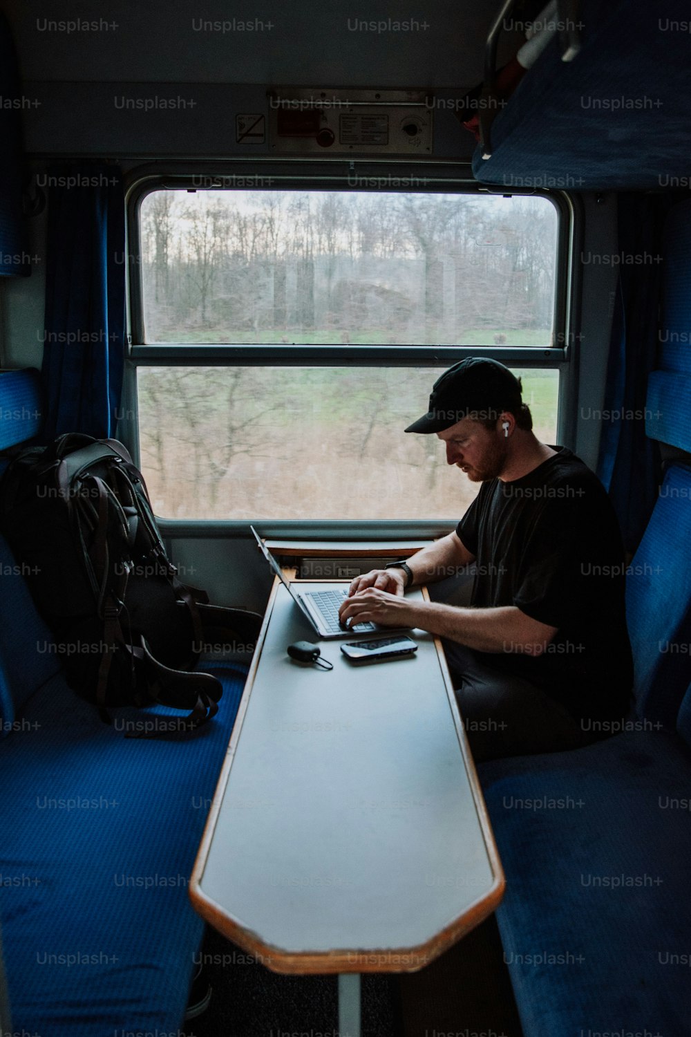 노트북 컴�퓨터를 사용하여 테이블에 앉아 있는 남자