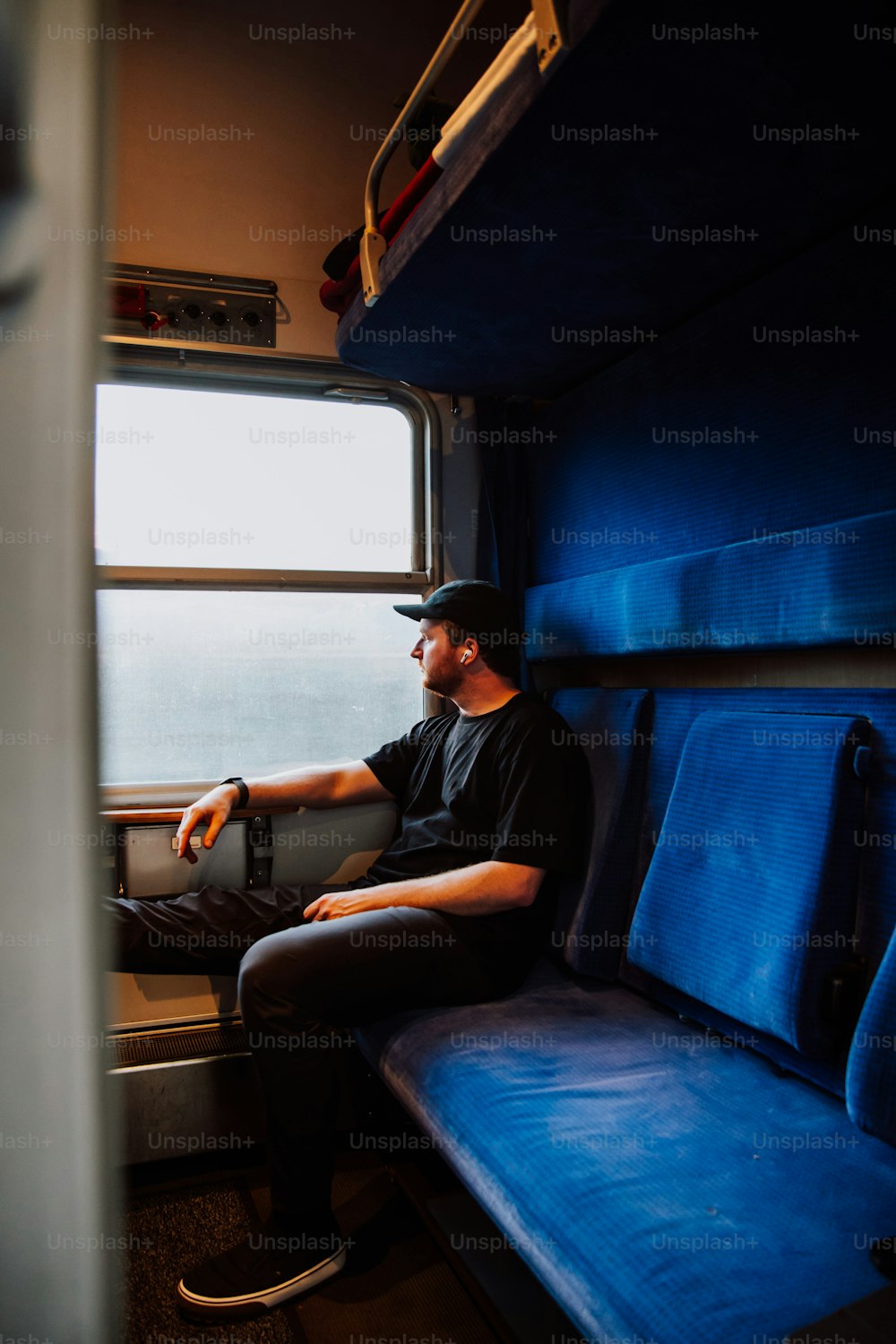 電車に座って窓の外を眺める男性