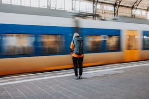 Una mujer parada en una plataforma frente a un tren