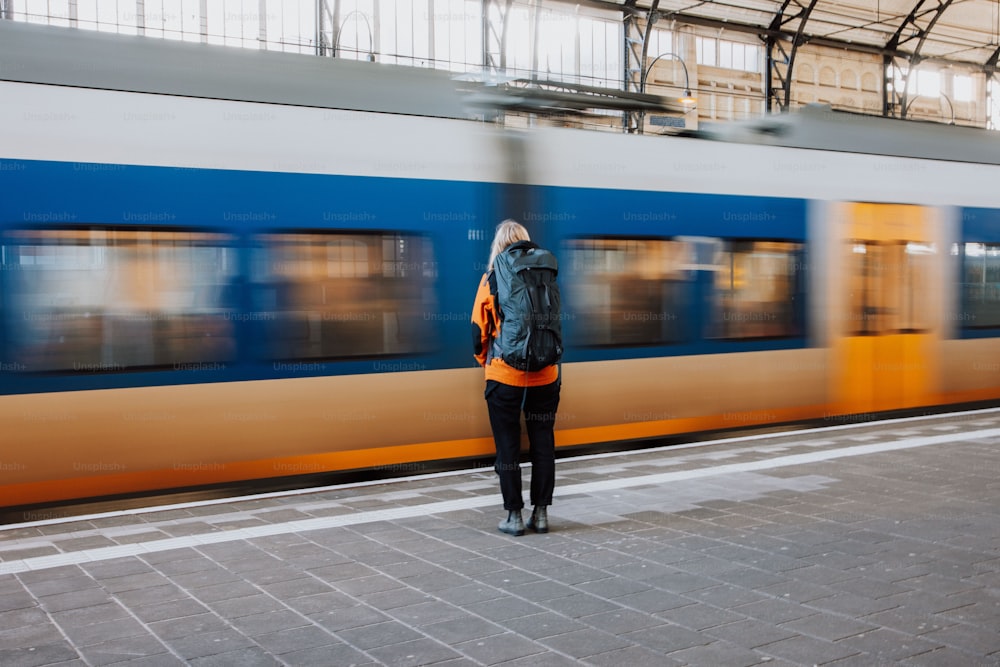 Una mujer parada en una plataforma frente a un tren