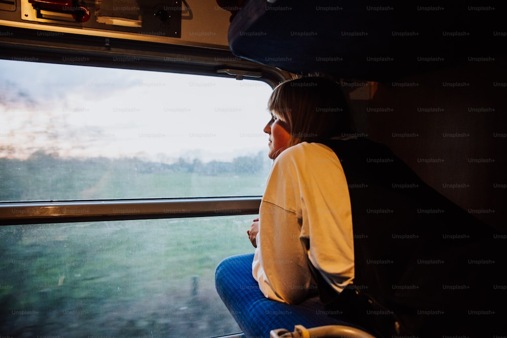 a woman sitting on a train looking out the window