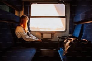 Une femme assise dans un train regardant par la fenêtre