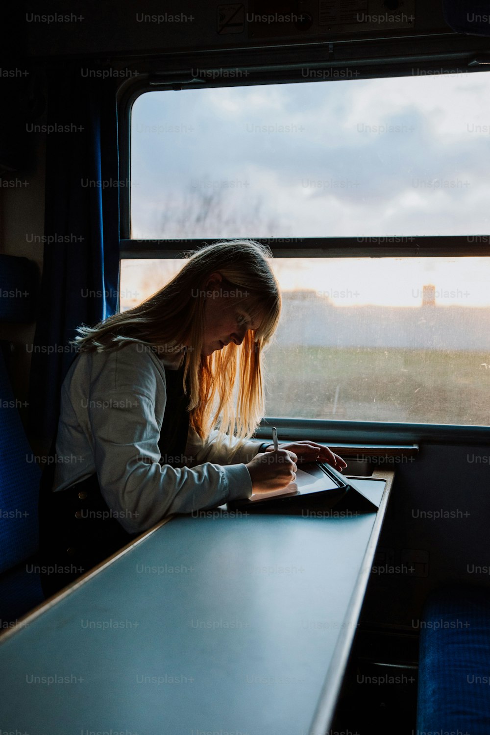 a woman sitting at a table using a laptop computer