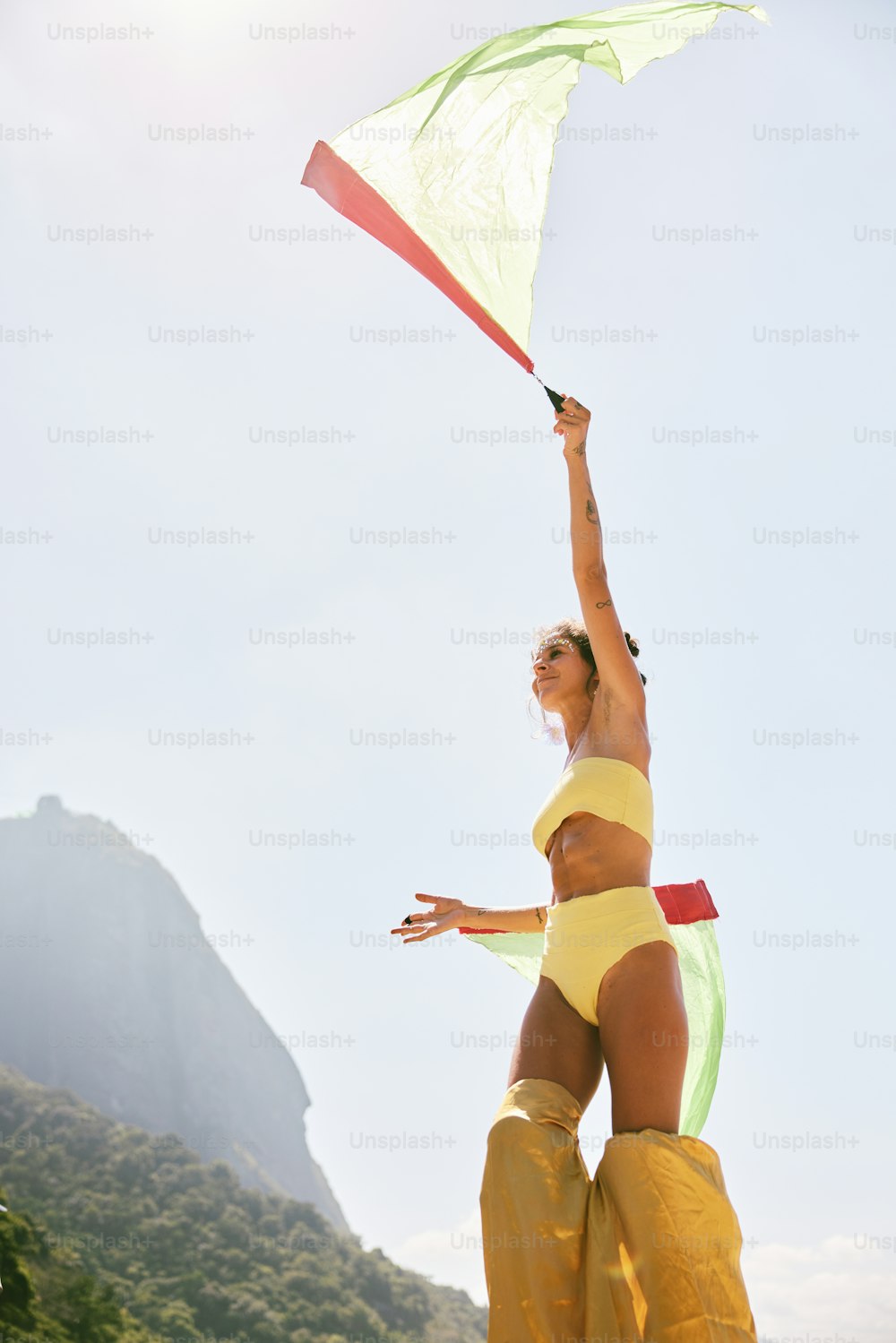 a woman in a bathing suit holding a kite