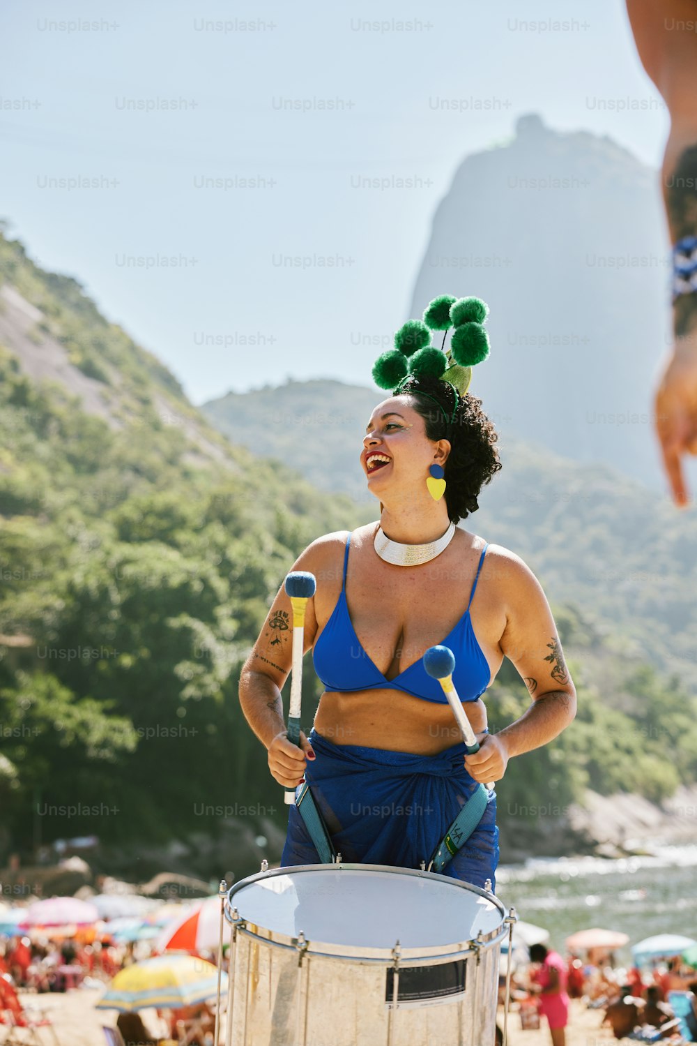 a woman in a bikini holding a metal drum