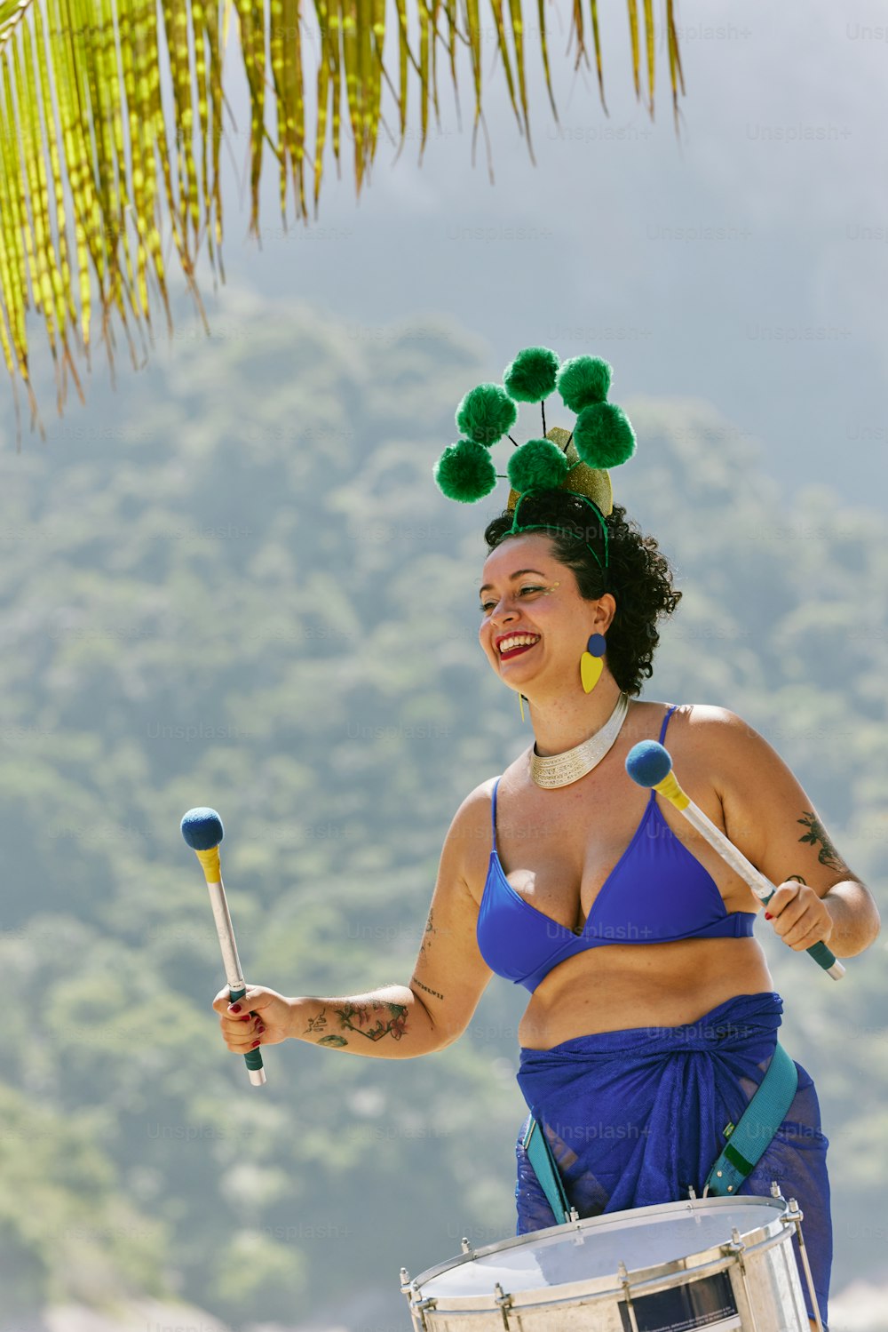 a woman in a blue bikini holding a drum