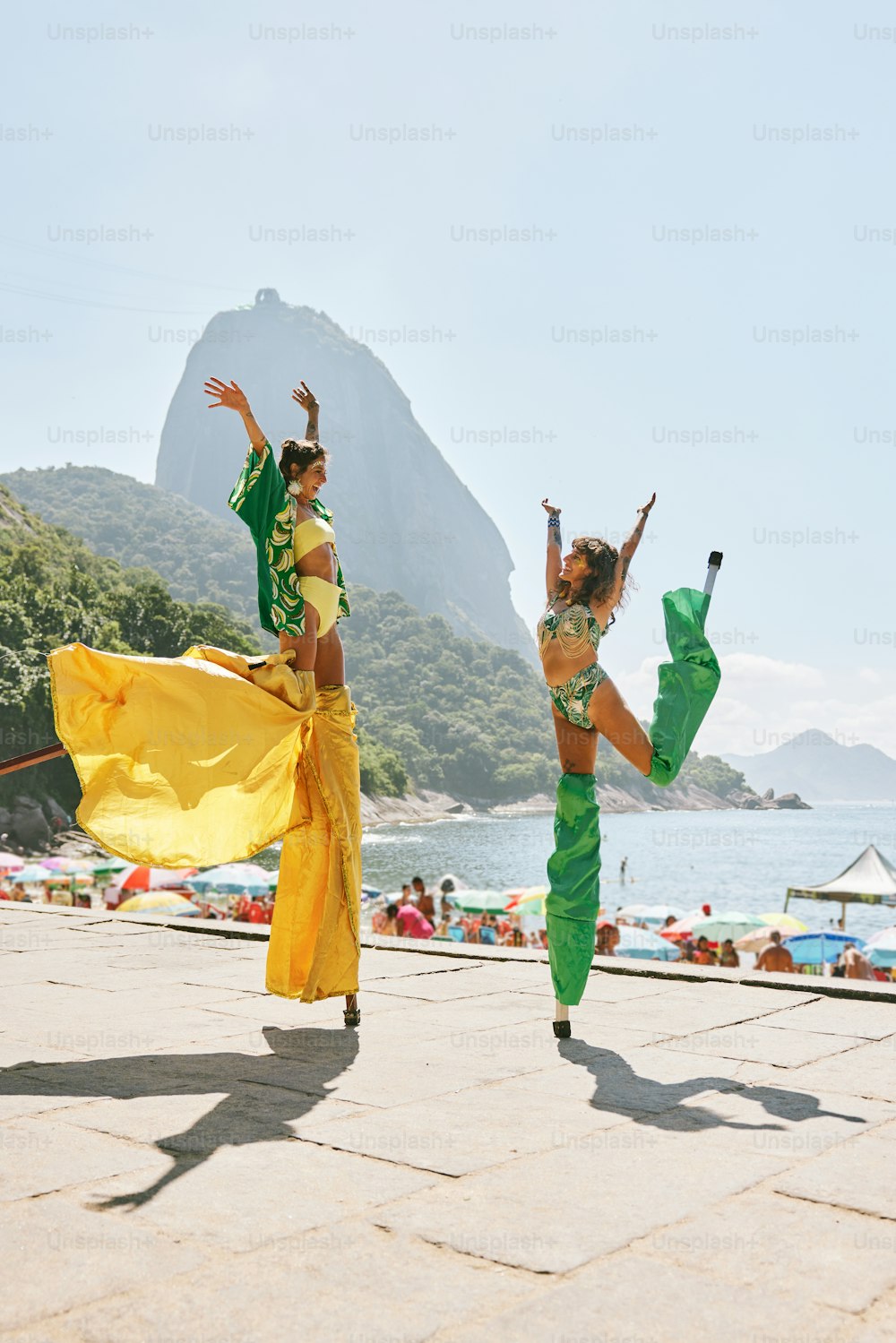 a couple of women standing on top of a sandy beach