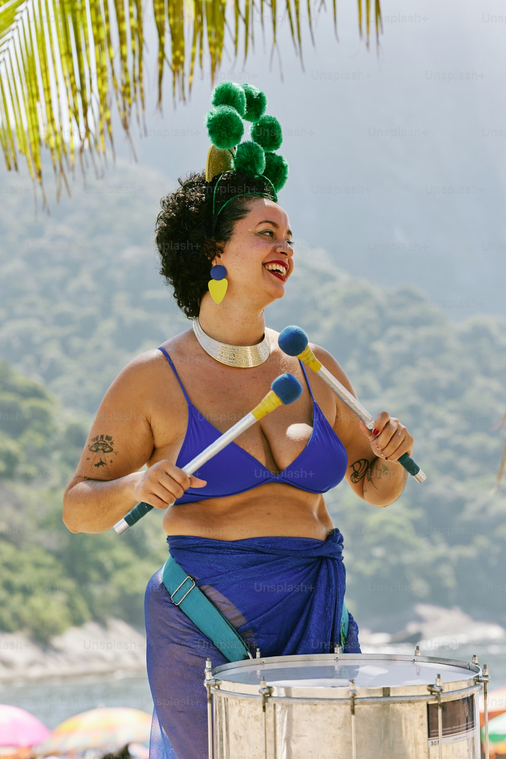 a woman in a blue bikini top playing a drum