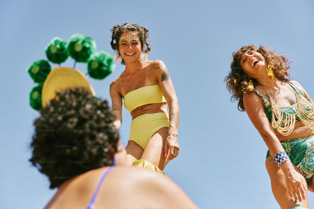 a woman in a yellow bikini standing next to a man in a green bikini