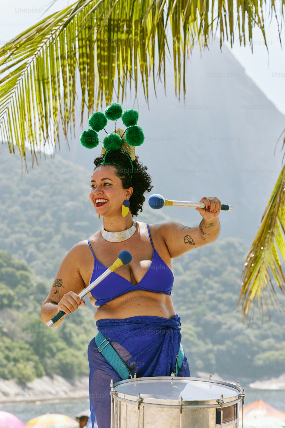 Una donna in un top bikini blu che suona un tamburo