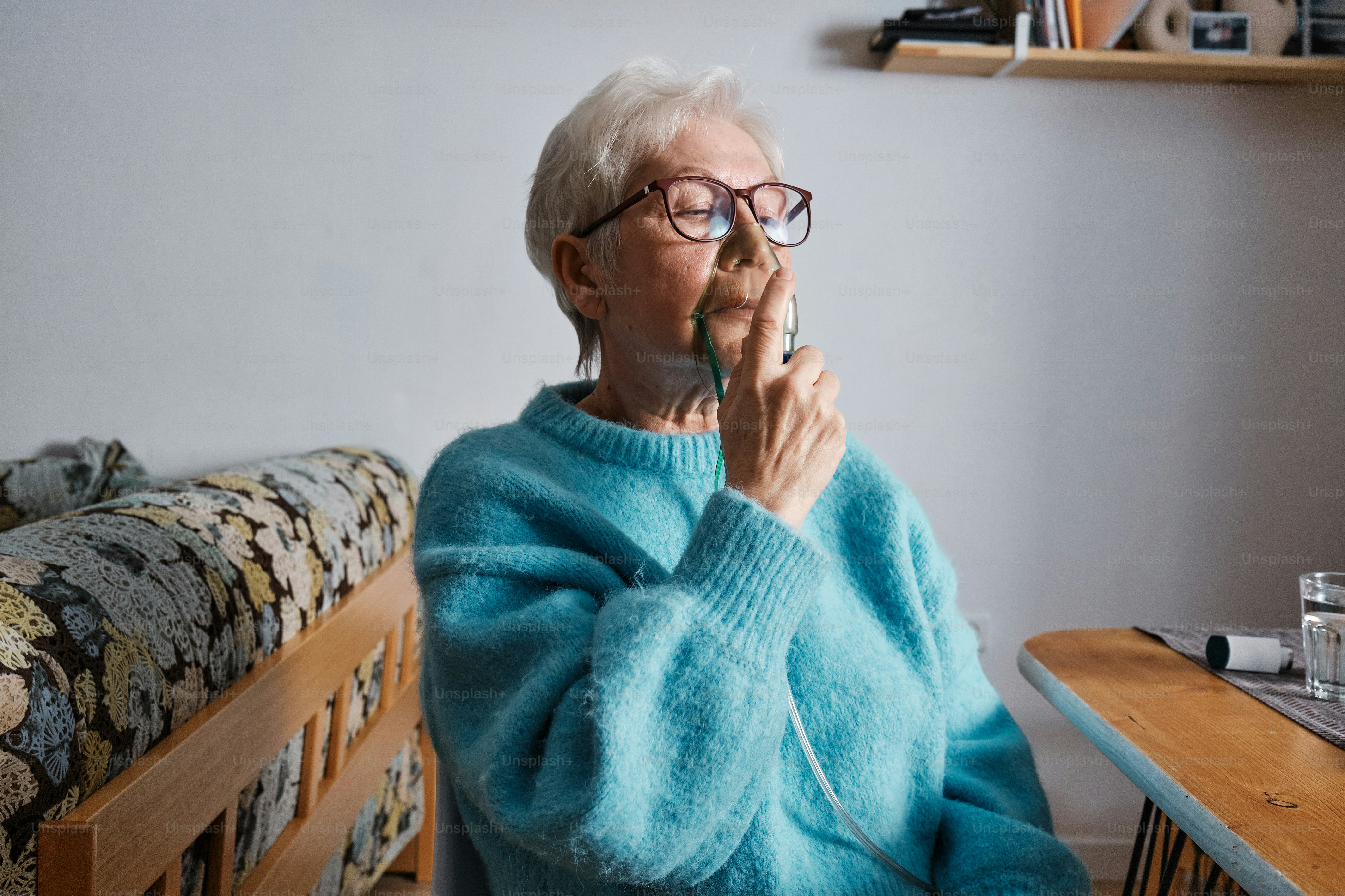 elderly woman at home breathing through an oxygen mask