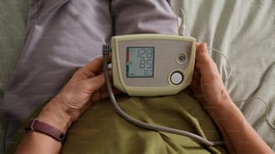 a person laying in a bed with a blood pressure meter