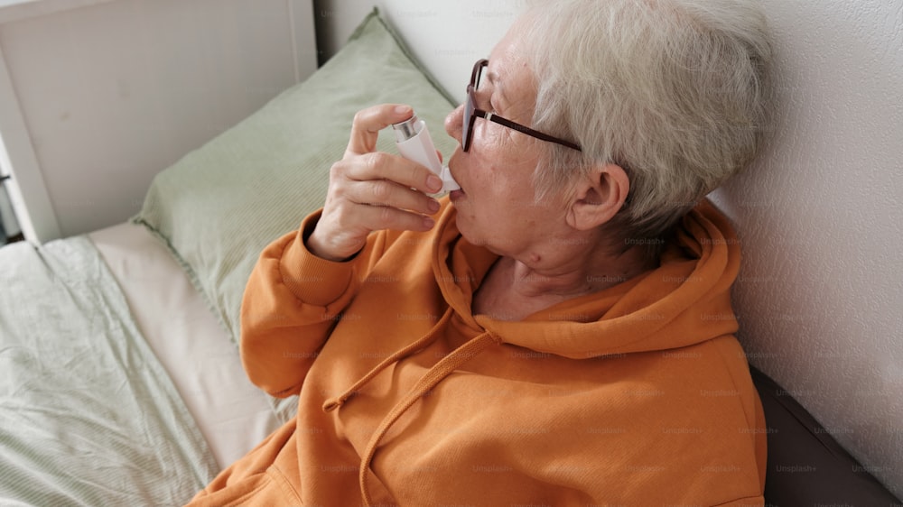 a woman in an orange shirt is sitting on a bed