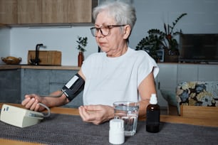 una mujer anciana usando un medidor de presión arterial