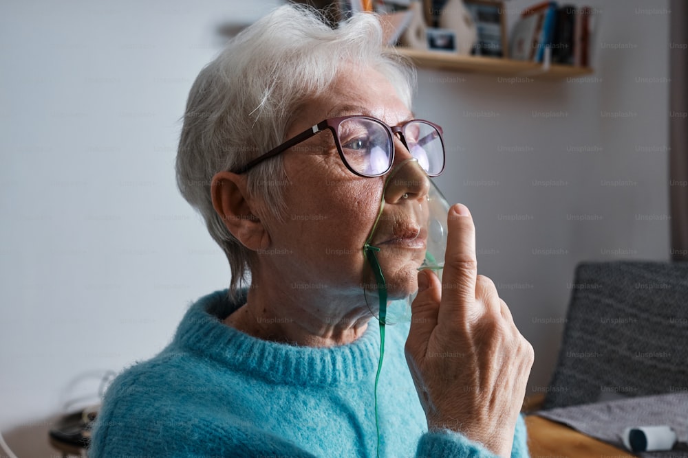 an older woman wearing glasses and holding a cell phone to her ear