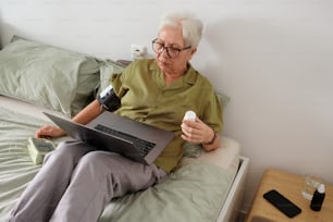 uma pessoa sentada em uma cama com um laptop