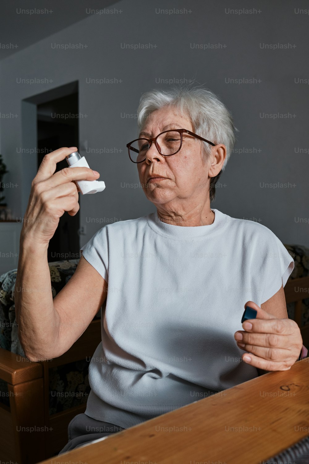 a woman sitting at a table holding a remote control