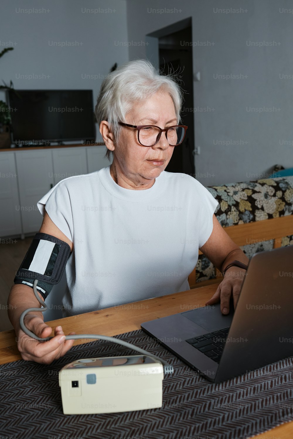 eine Frau mit Gips am Arm mit einem Laptop