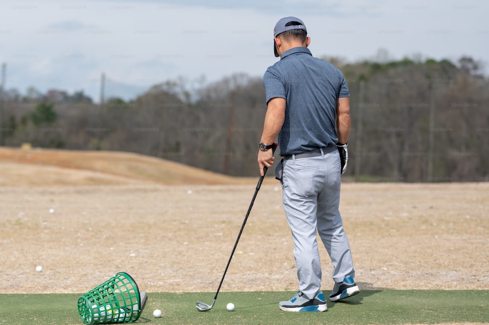 um homem que joga golfe em um campo de golfe