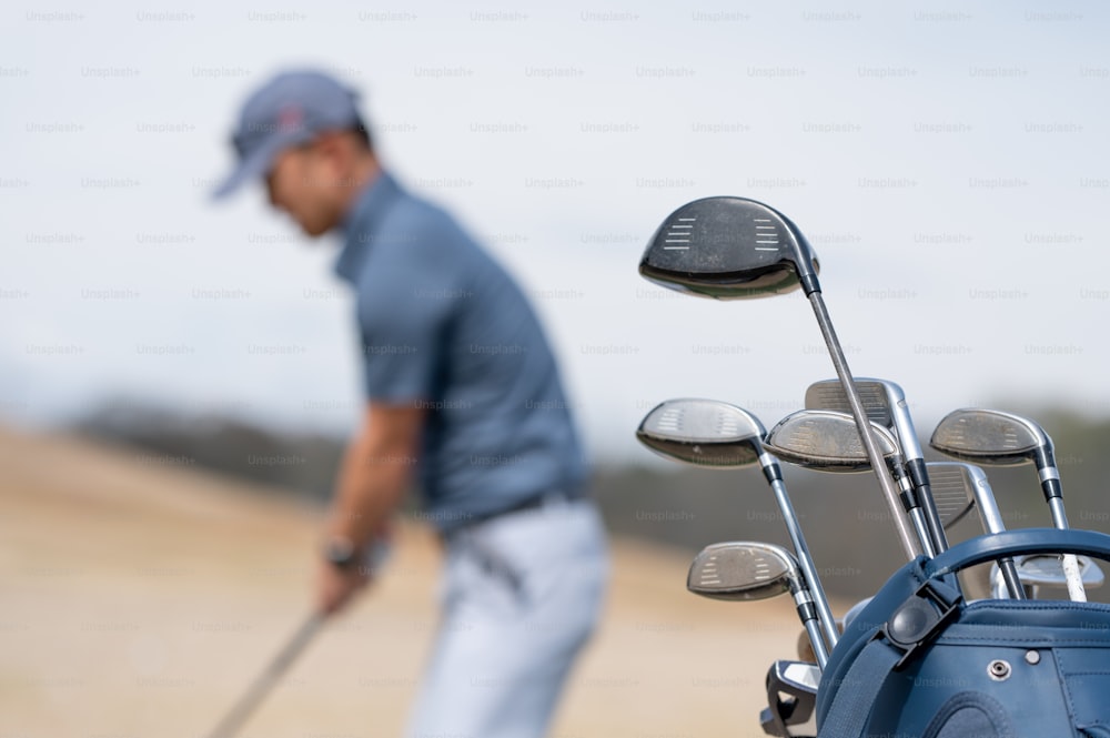 ゴルフクラブとゴルフクラブのバッグを持つ男