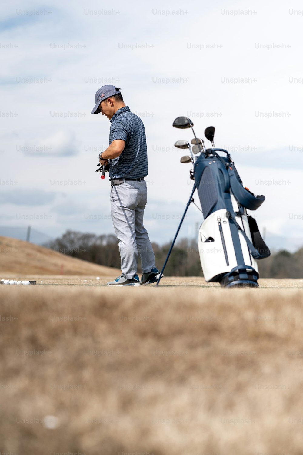um homem de pé ao lado de um saco de golfe