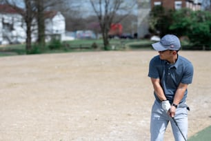 Ein Mann, der einen Golfschläger auf einem Golfplatz hält