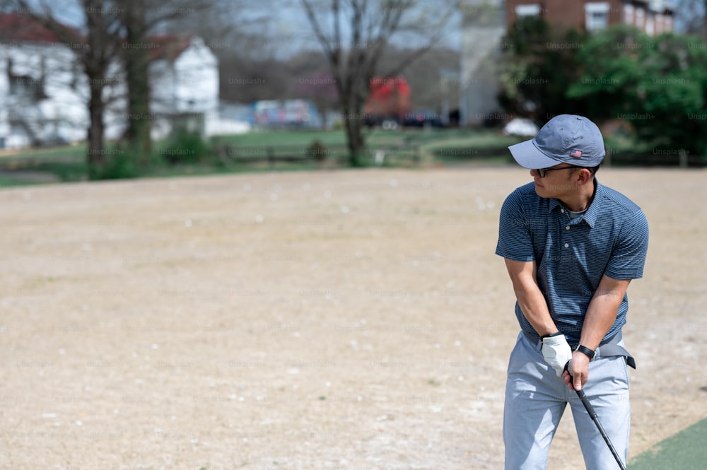 um homem segurando um taco de golfe em um campo de golfe