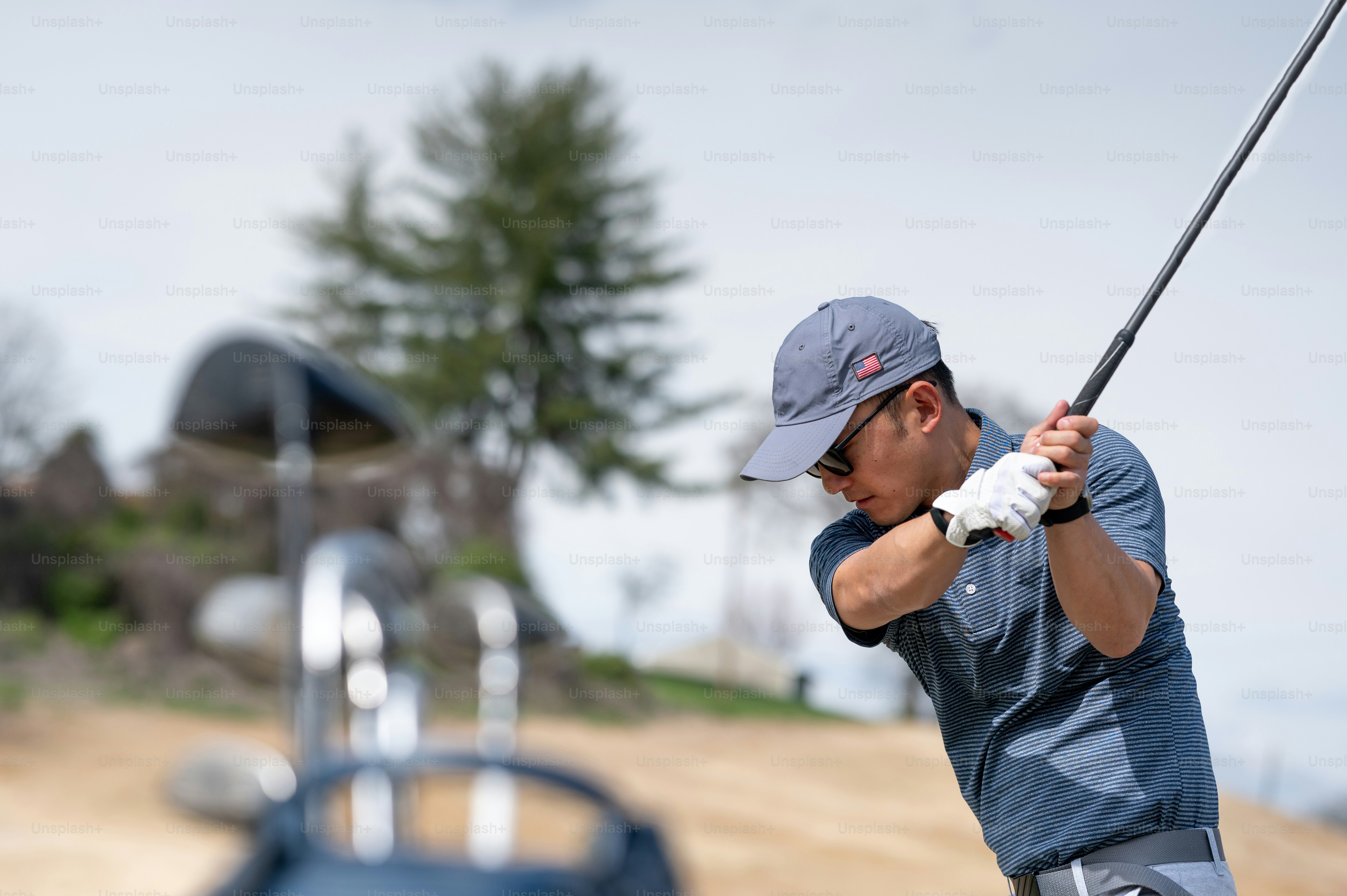 A man swinging a golf club on a golf course photo Golf Image on Unsplash