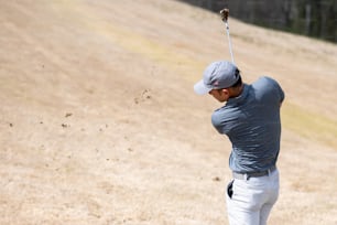 a man hitting a golf ball with a golf club