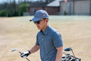 a man in a blue shirt and hat holding a golf club
