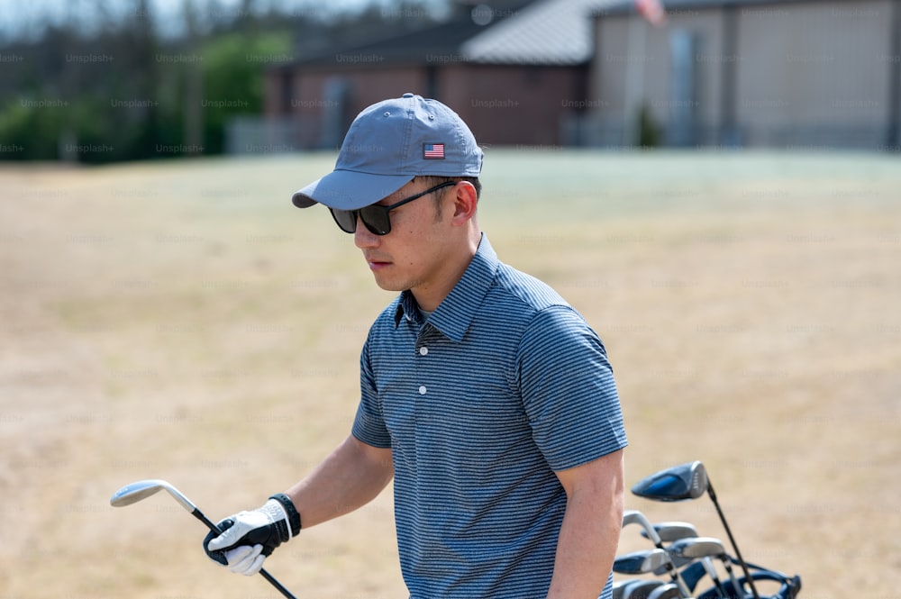 a man in a blue shirt and hat holding a golf club