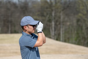 Ein Mann im blauen Hemd, der einen Golfschläger in der Hand hält