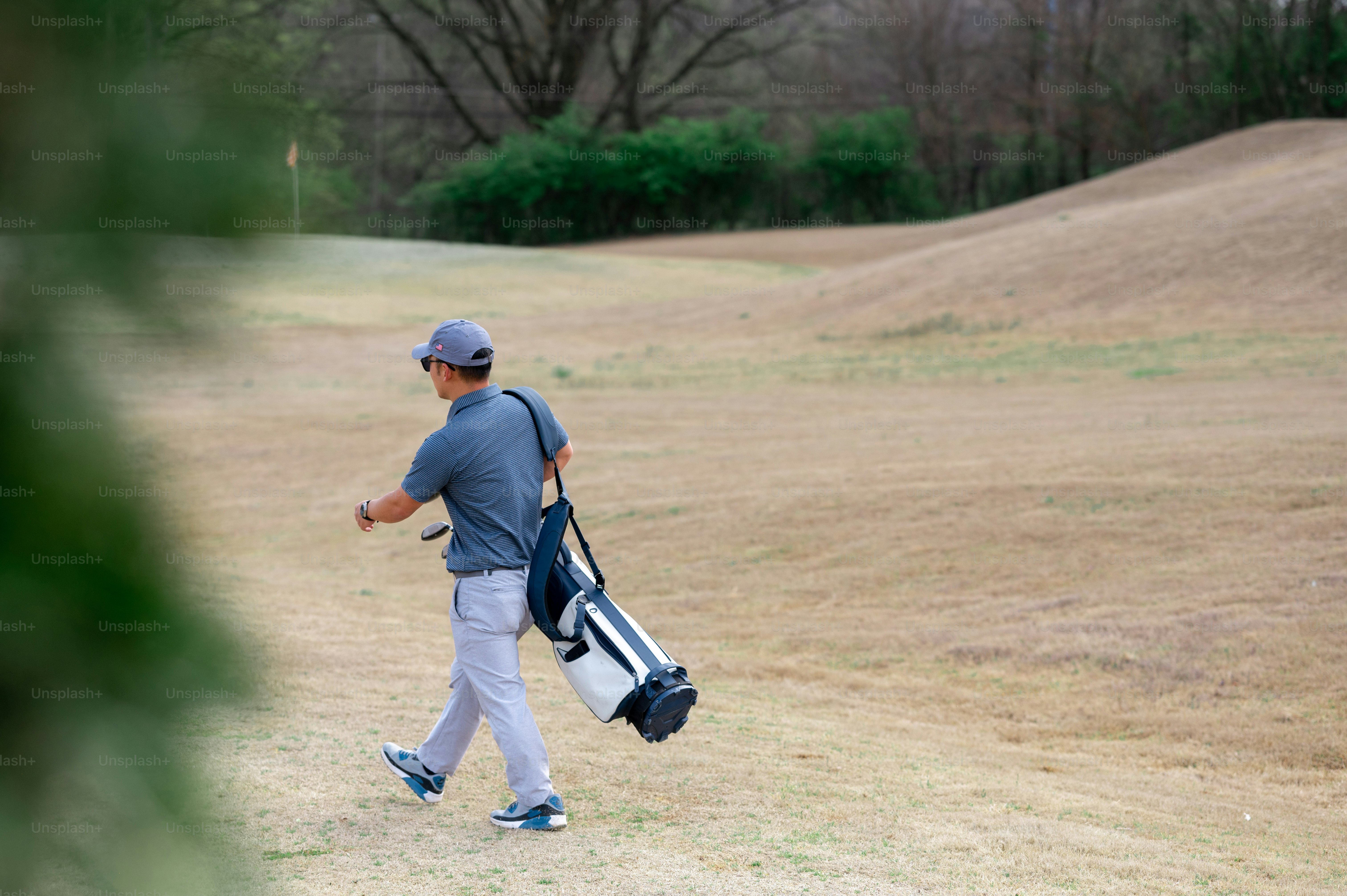 a man walking across a grass covered field