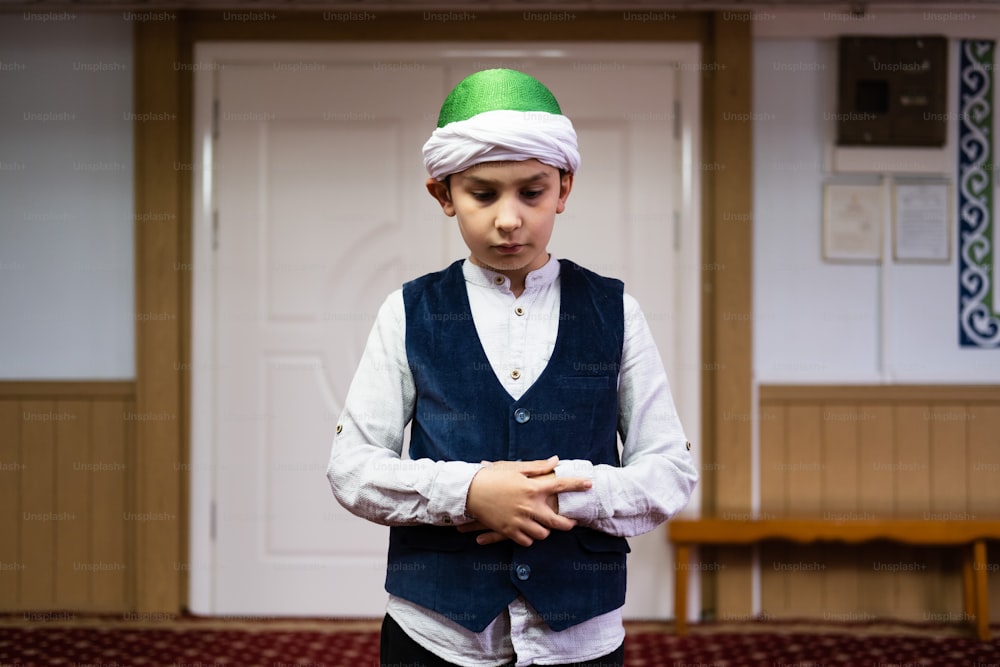 a young boy wearing a green and white turban